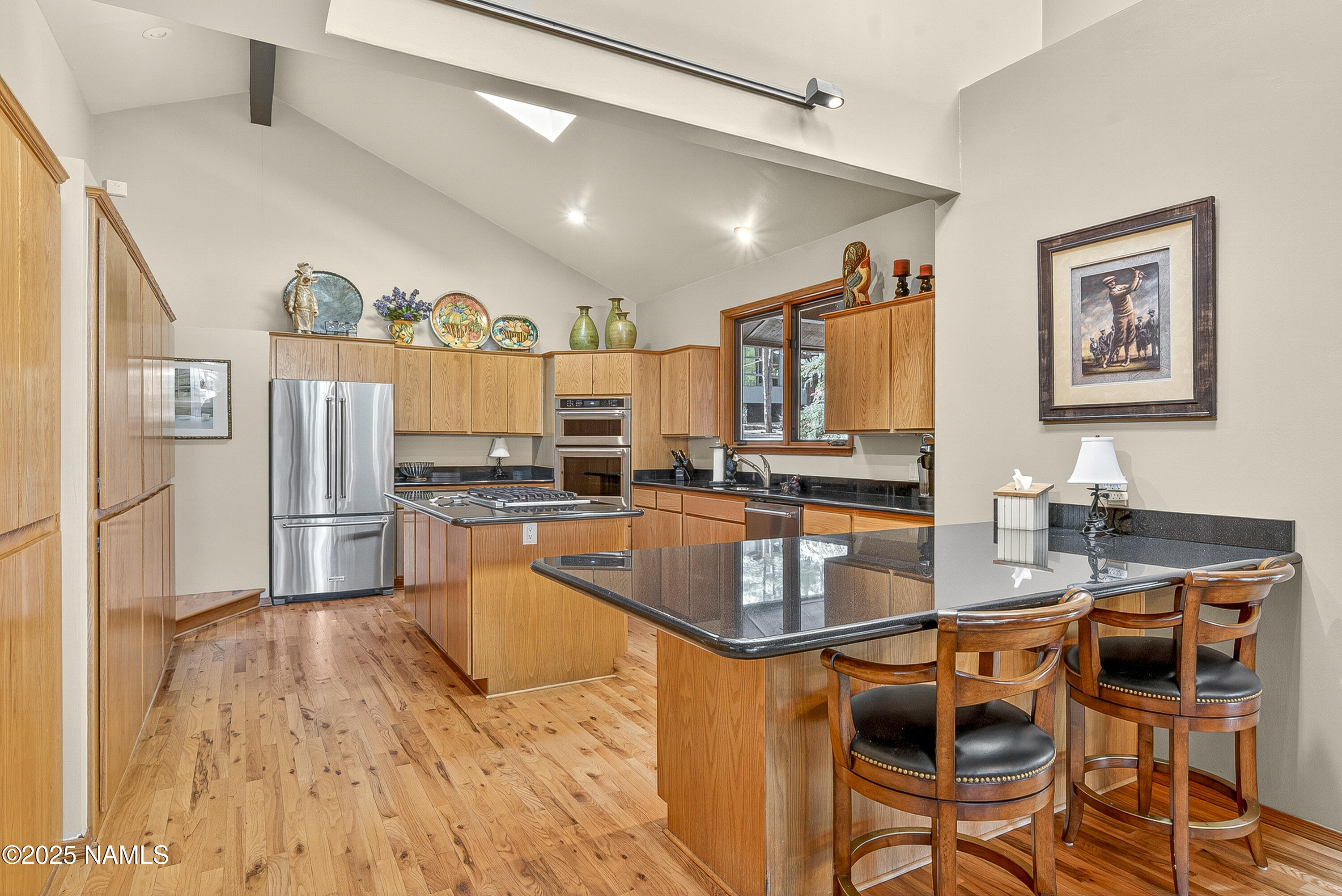 5790 Griffiths Spring Flagstaff, AZ 86005 - Photo 23 of 47 a kitchen with stainless steel appliances granite countertop a refrigerator a stove a sink a dining table and chairs with wooden floor
