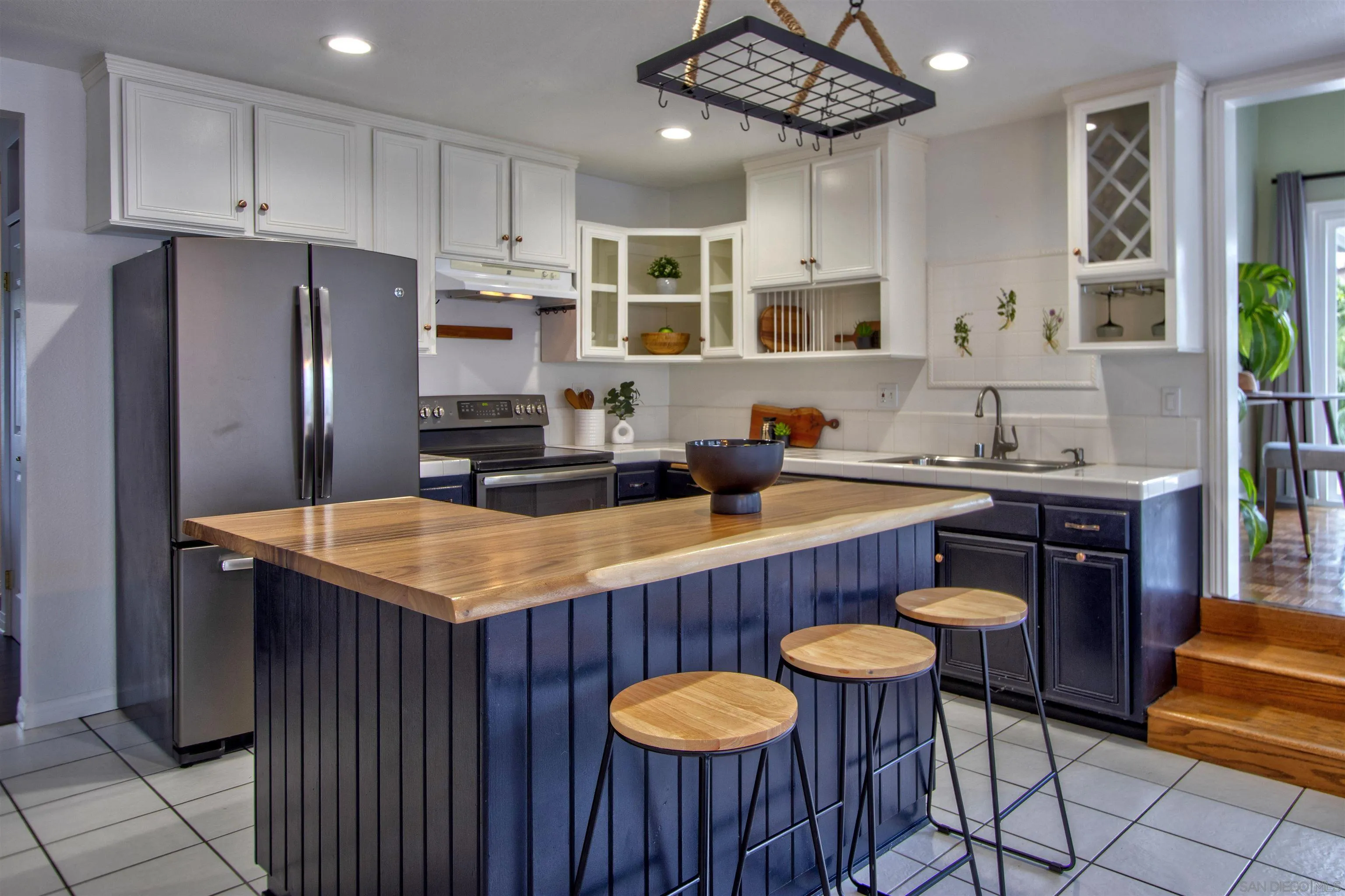 8450 Aries Road San Diego, CA 92126 - Photo 11 of 25 a kitchen with stainless steel appliances granite countertop a table chairs sink refrigerator and microwave