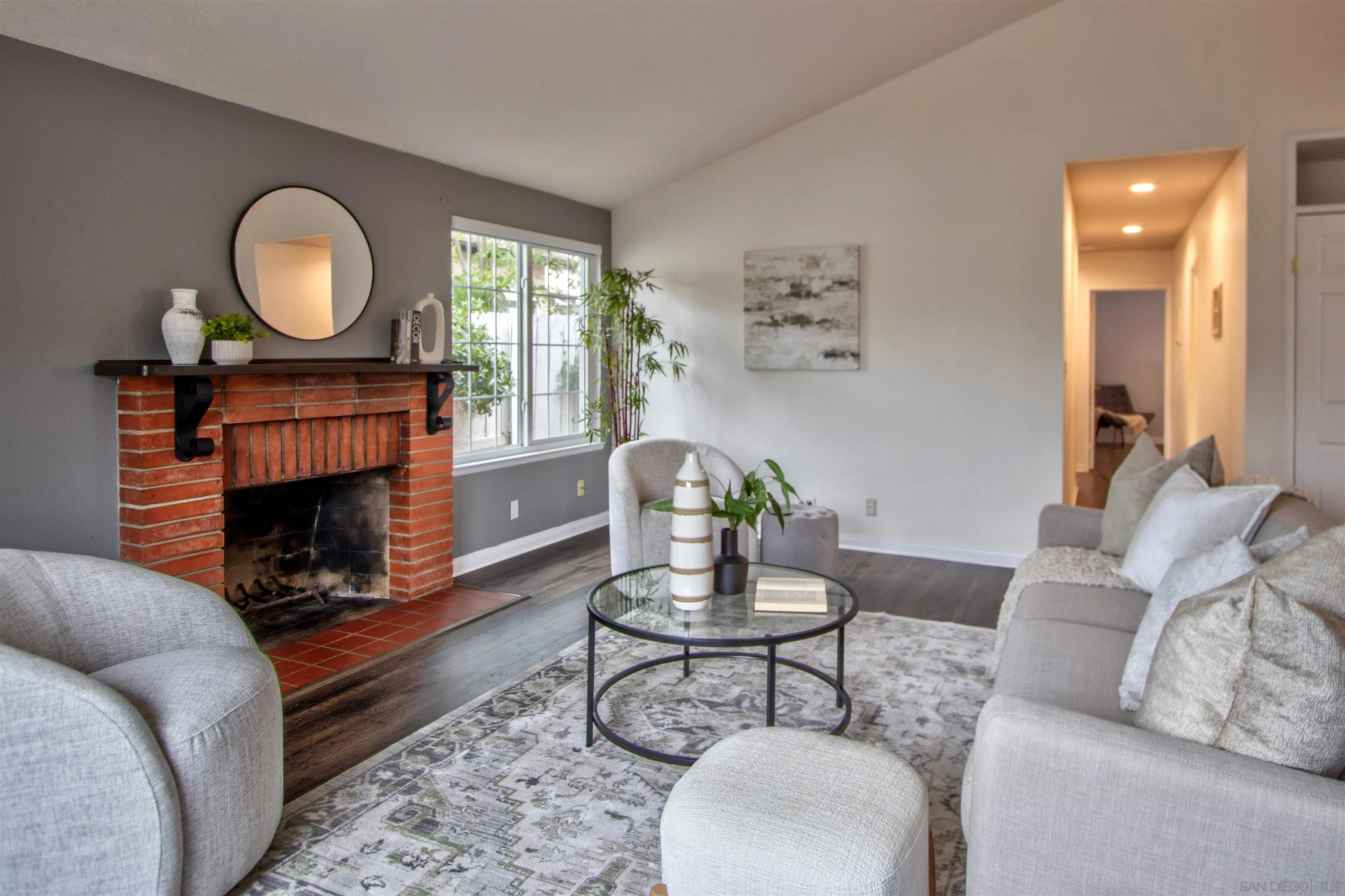 8450 Aries Road San Diego, CA 92126 - Photo 3 of 25 a living room with furniture a fireplace and a table