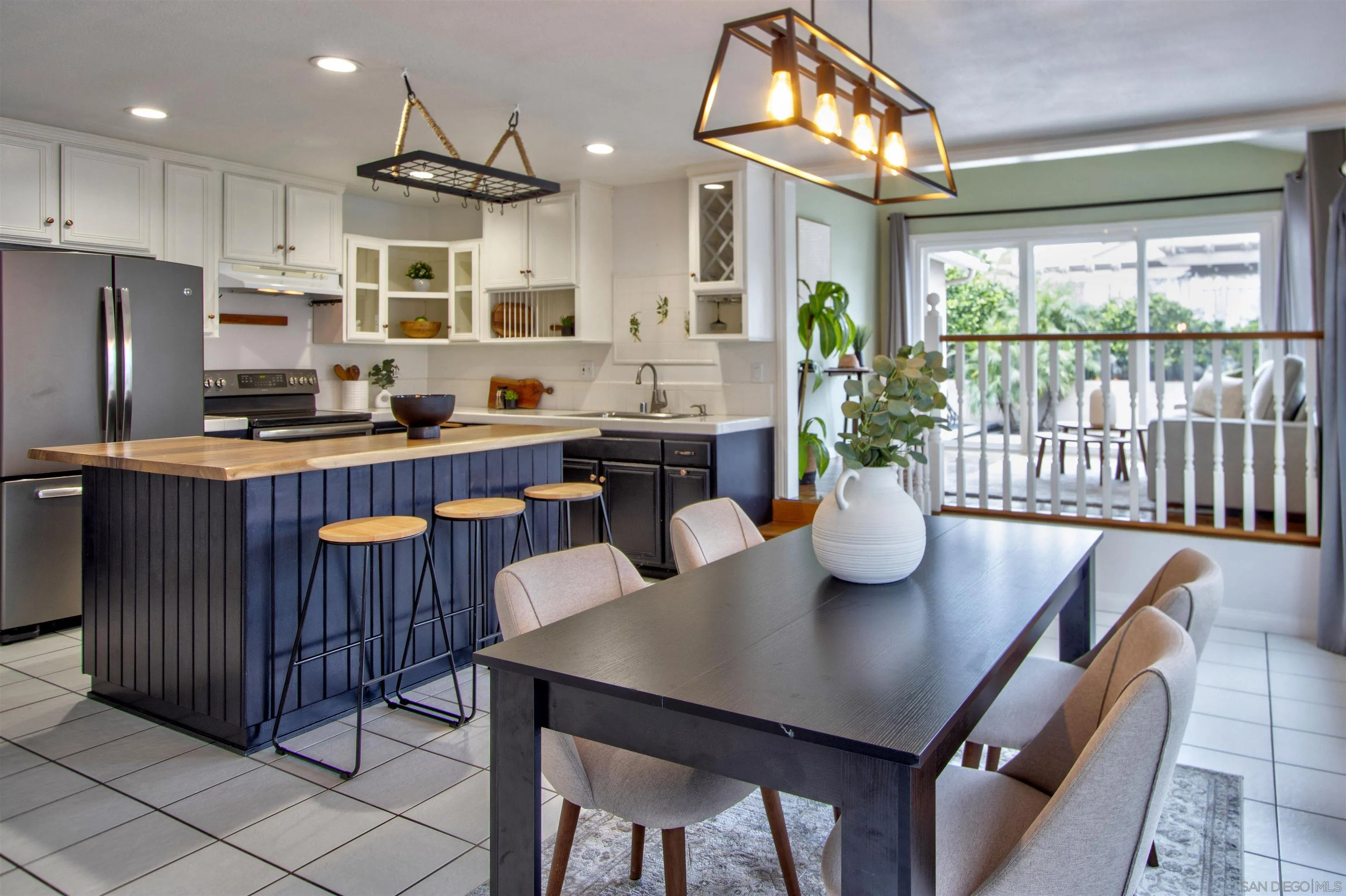 8450 Aries Road San Diego, CA 92126 - Photo 9 of 25 a kitchen with a table chairs refrigerator and microwave
