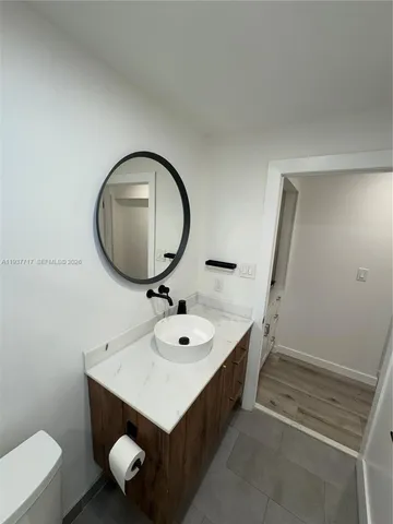 a bathroom with a sink mirror vanity and toilet