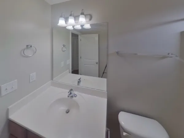 a bathroom with a sink a toilet and a mirror