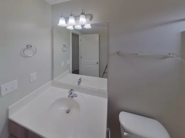 a bathroom with a sink a toilet and a mirror