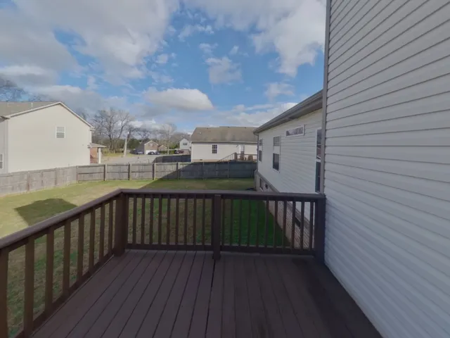 a view of roof deck with wooden floor and fence
