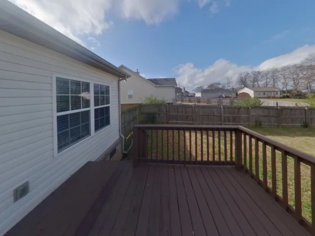 a view of balcony with wooden floor and fence