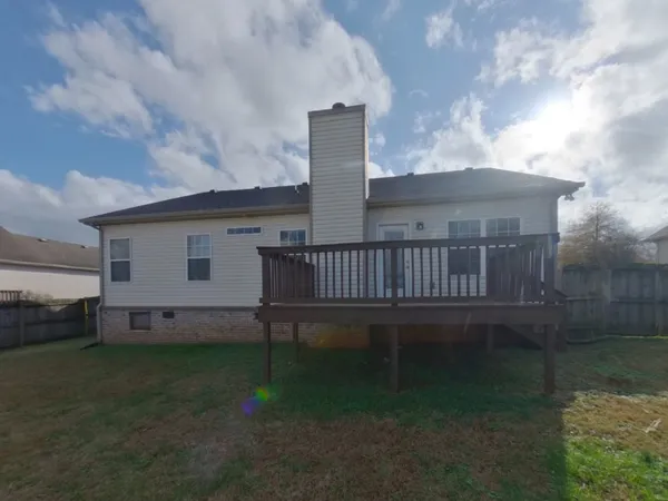 a view of a house with wooden deck and a yard
