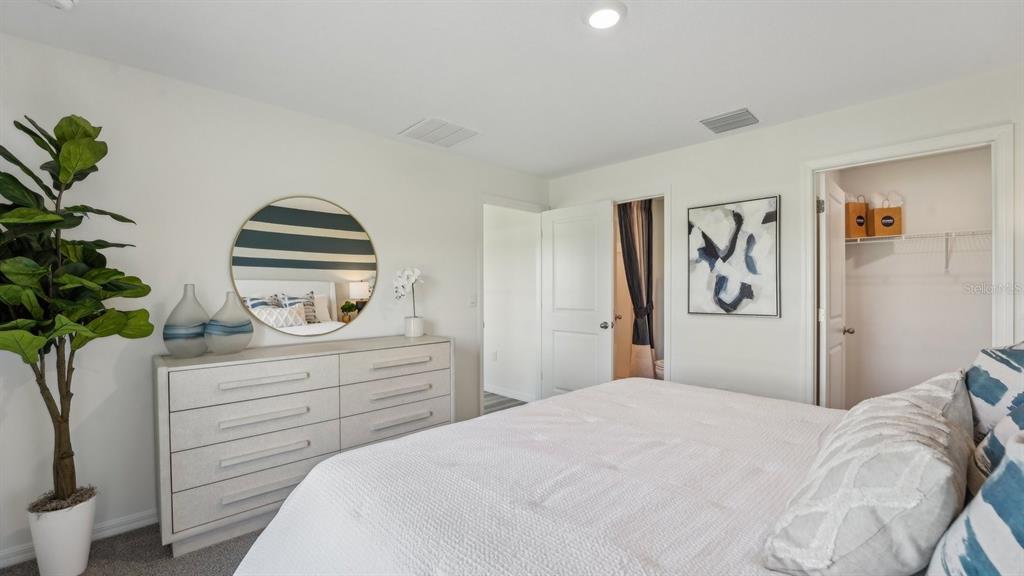 15898 Southeast 101st Ct Road Summerfield, FL 34491 - Photo 16 of 29 a bedroom with a bed and a plant