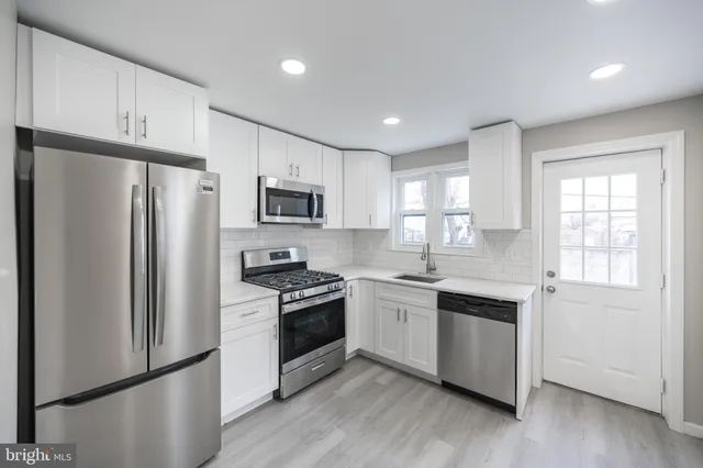 a kitchen with stainless steel appliances granite countertop a refrigerator stove and sink