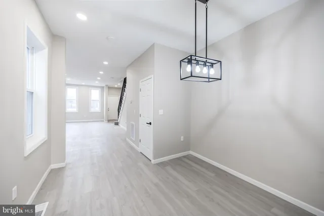 a view of a hallway with wooden floor and chandelier