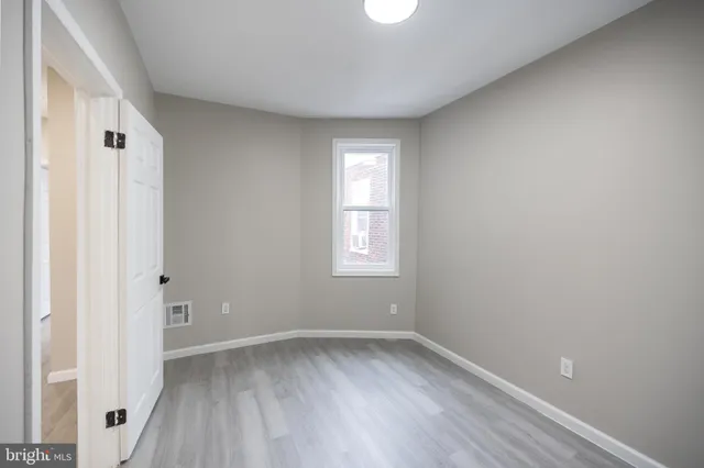 a view of a room with wooden floor and window