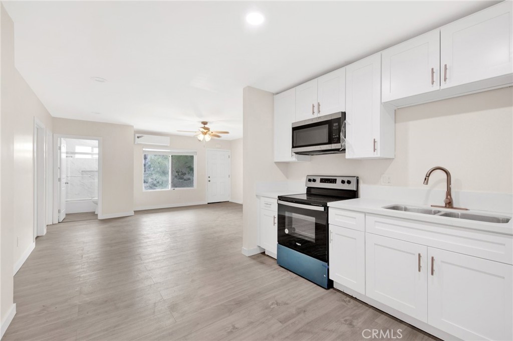 12540 Dexter Park Road Sylmar, CA 91342 - Photo 12 of 31 a kitchen with stainless steel appliances granite countertop a stove top oven a sink dishwasher and a refrigerator with wooden floor