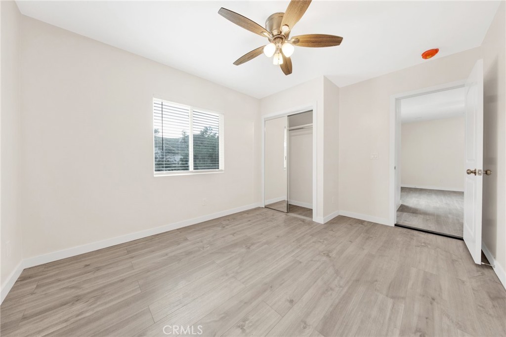 12540 Dexter Park Road Sylmar, CA 91342 - Photo 14 of 31 an empty room with wooden floor chandelier fan and windows