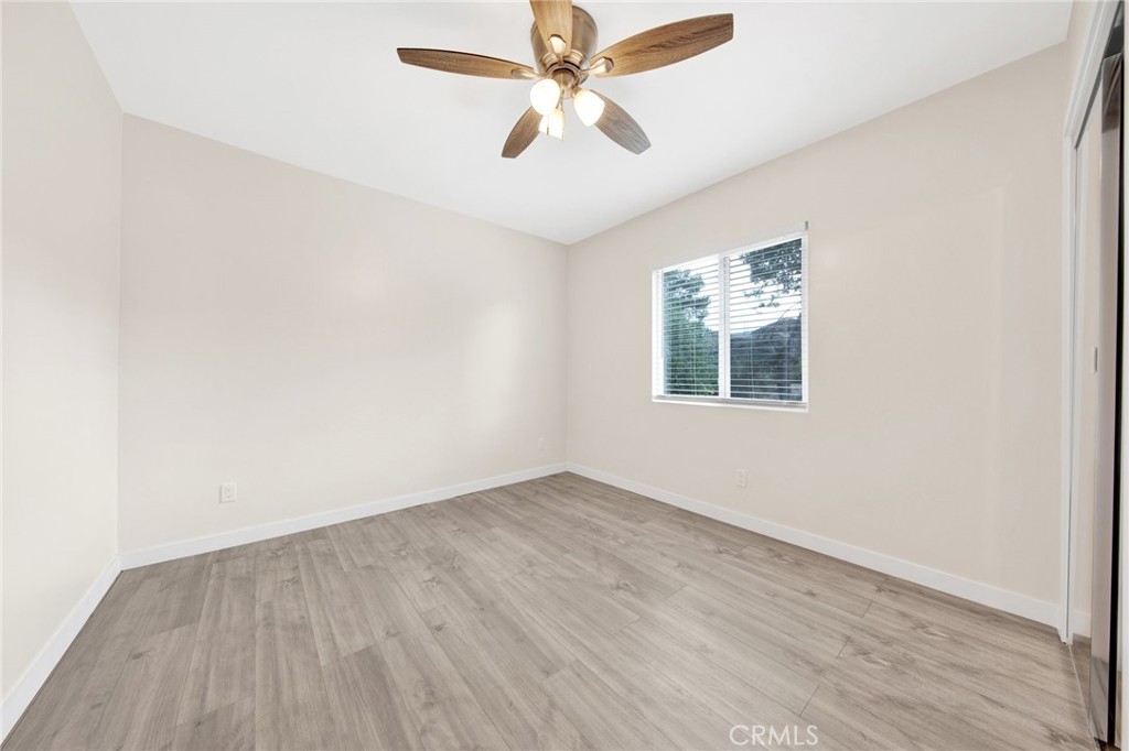 12540 Dexter Park Road Sylmar, CA 91342 - Photo 15 of 31 an empty room with wooden floor chandelier fan and windows