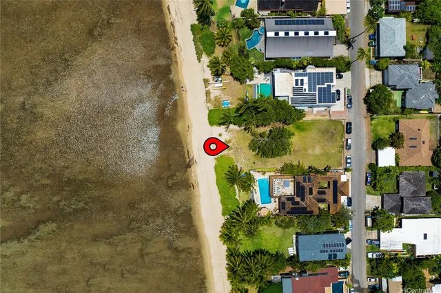 an aerial view of residential houses with outdoor space and ocean view