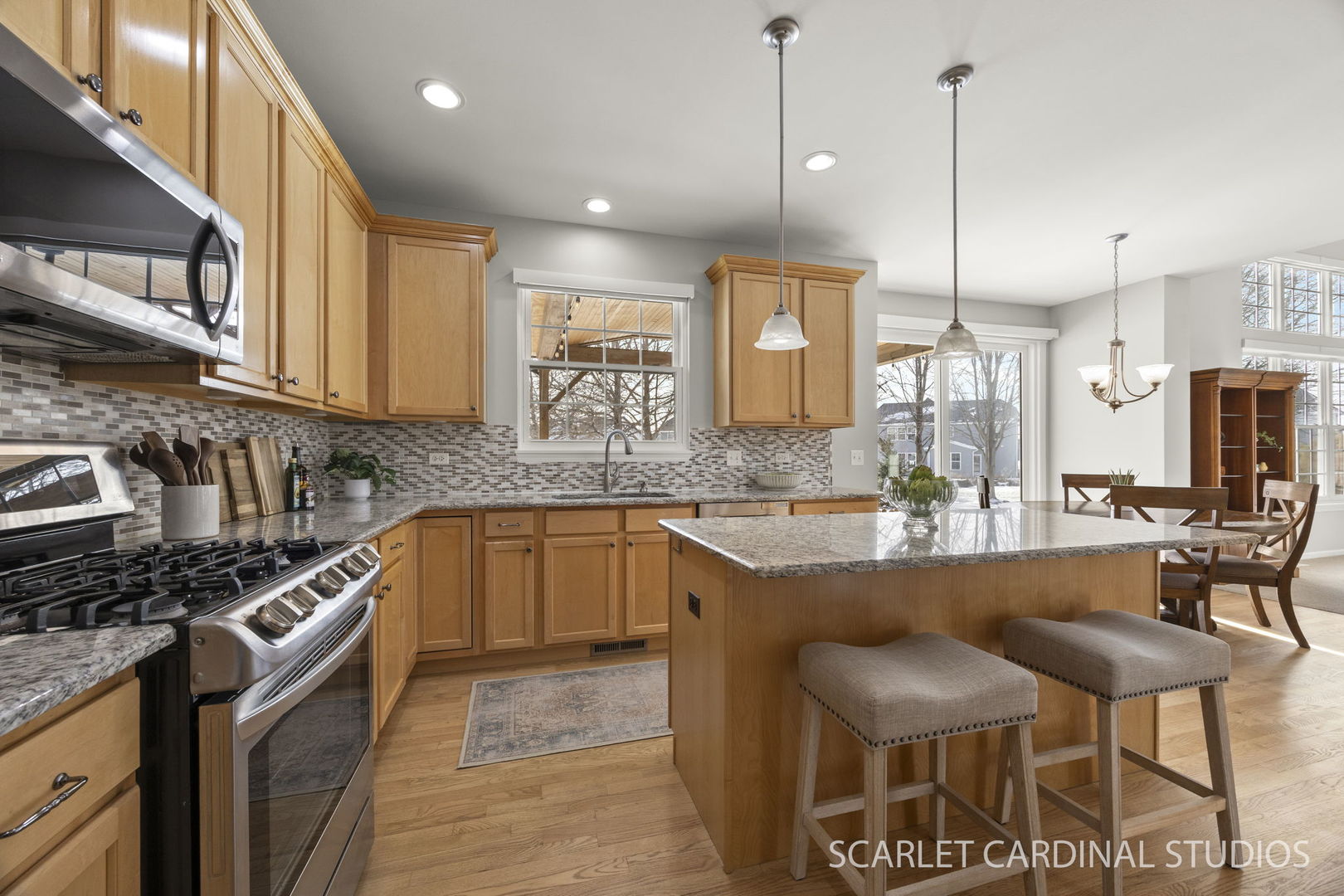 26115 Mapleview Drive Plainfield, IL 60585 - Photo 4 of 36 a kitchen with stainless steel appliances granite countertop a stove a sink a oven a dining table and chairs with wooden floor