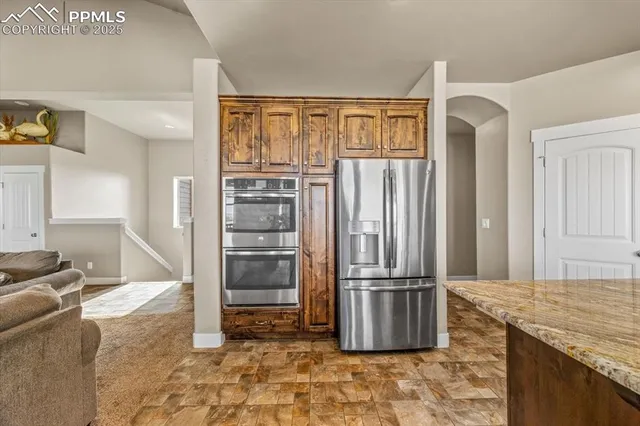 a kitchen with granite countertop a refrigerator and a sink