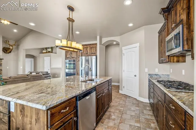 a kitchen with stainless steel appliances granite countertop a stove and cabinets