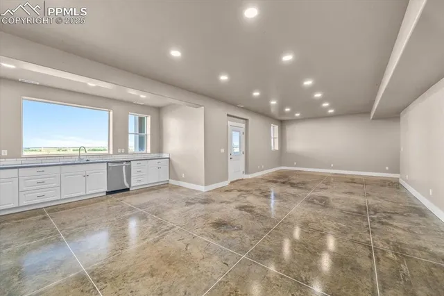 an empty room with windows and fan