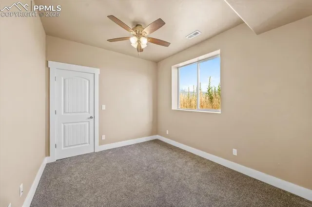 an empty room with windows and fan
