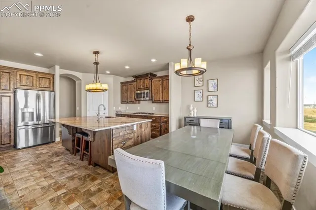 a view of a dining room and livingroom with furniture wooden floor a chandelier