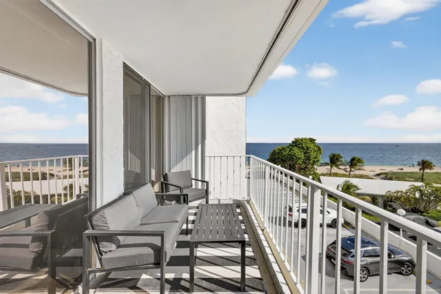 a view of a balcony with furniture and floor to ceiling window