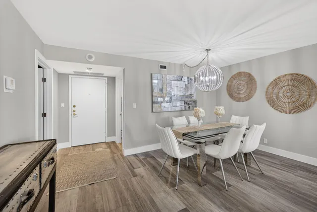 a view of a dining room with furniture a chandelier and wooden floor