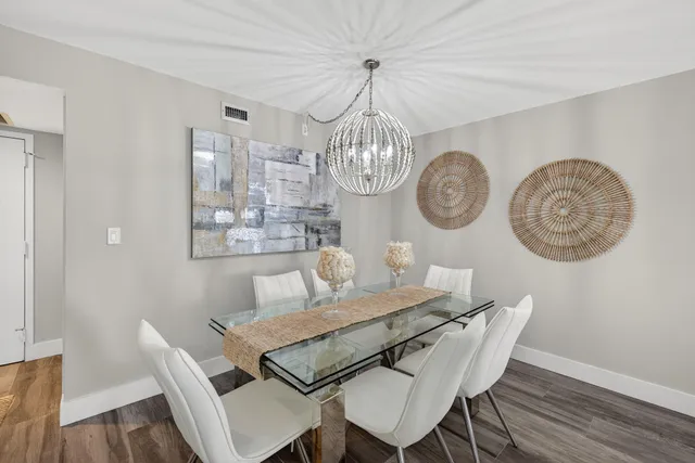 a view of a dining room with furniture a chandelier and wooden floor