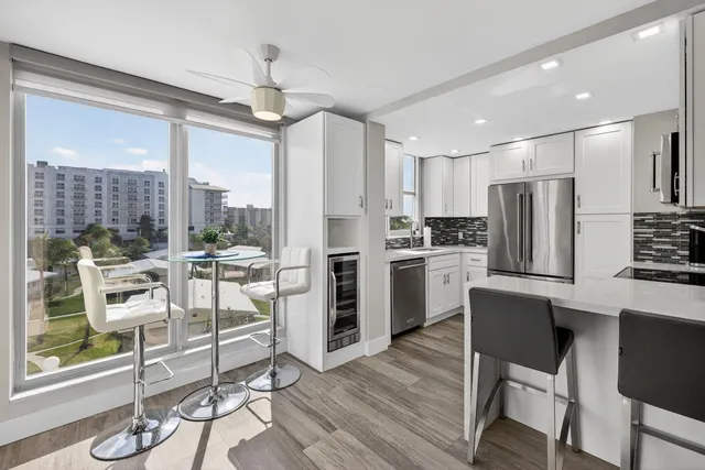 a kitchen with a table chairs refrigerator and microwave