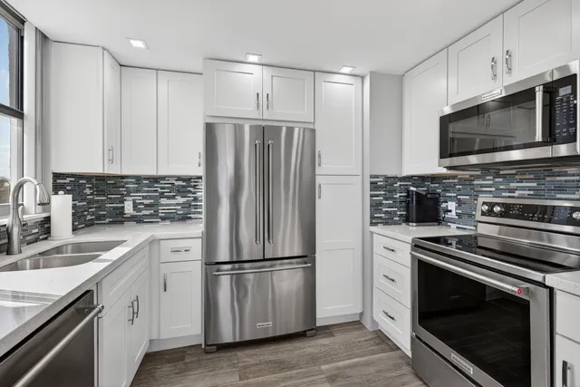 a kitchen with stainless steel appliances a refrigerator sink and cabinets