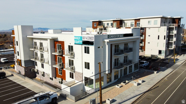 View of condominium building / complex with uncovered parking