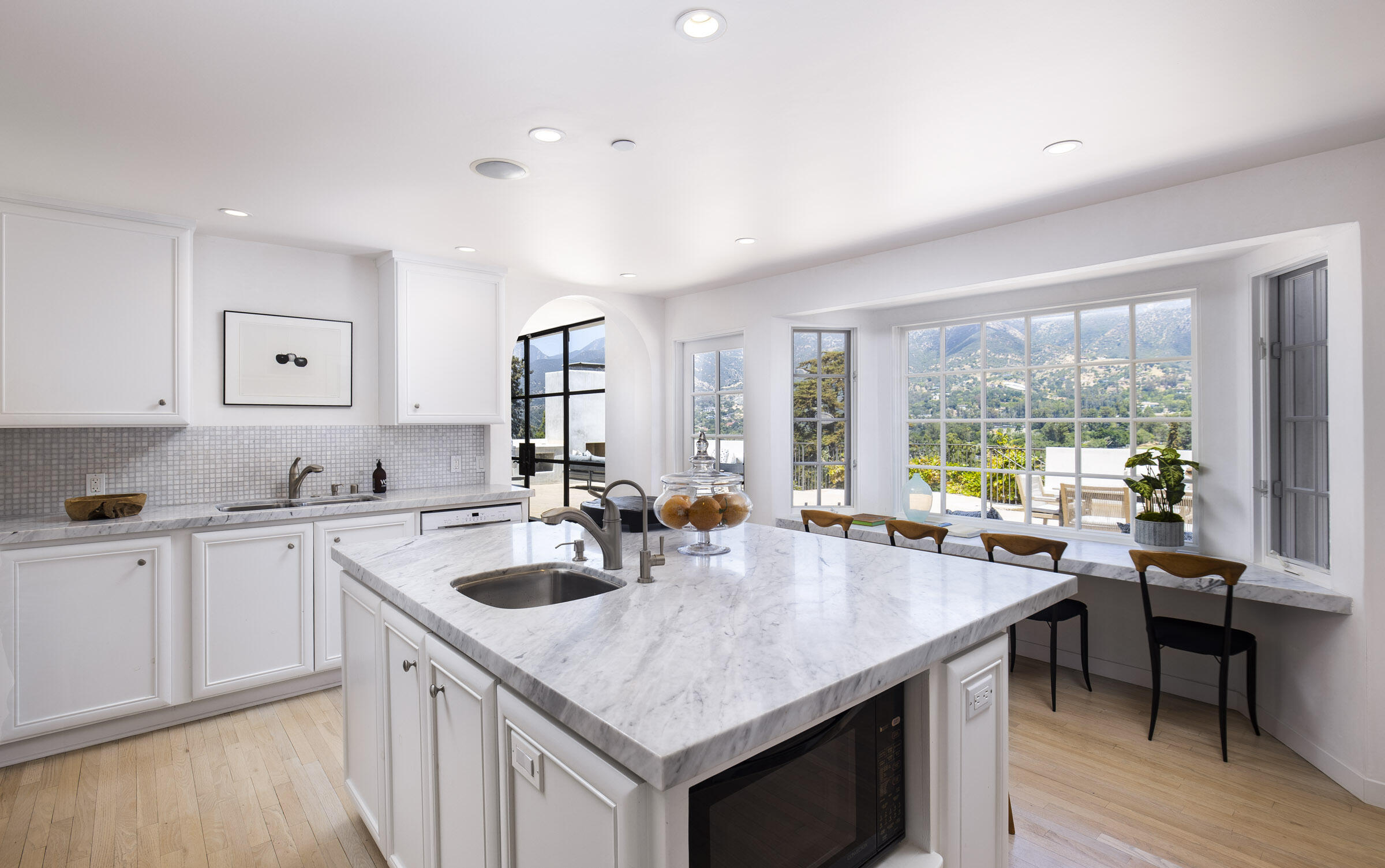 612 Cowles Road Montecito, CA 93108 - Photo 8 of 26 a open kitchen with stainless steel appliances granite countertop a sink a stove and white cabinets with wooden floor