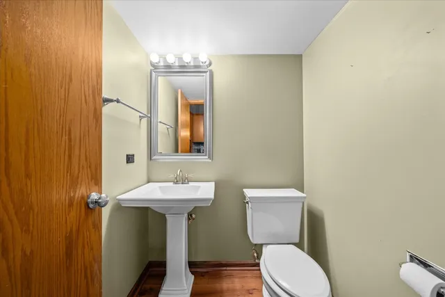 a bathroom with a toilet a sink and mirror
