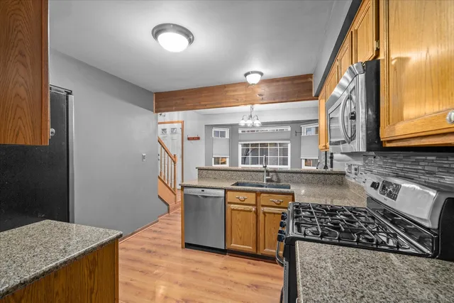 a kitchen with stainless steel appliances granite countertop a stove and a sink