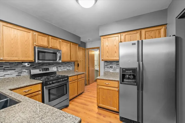 a kitchen with stainless steel appliances granite countertop a refrigerator stove and oven