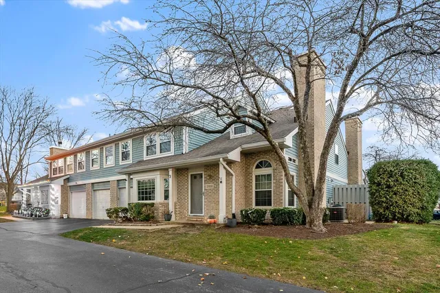 a view of a brick building next to a yard with big trees