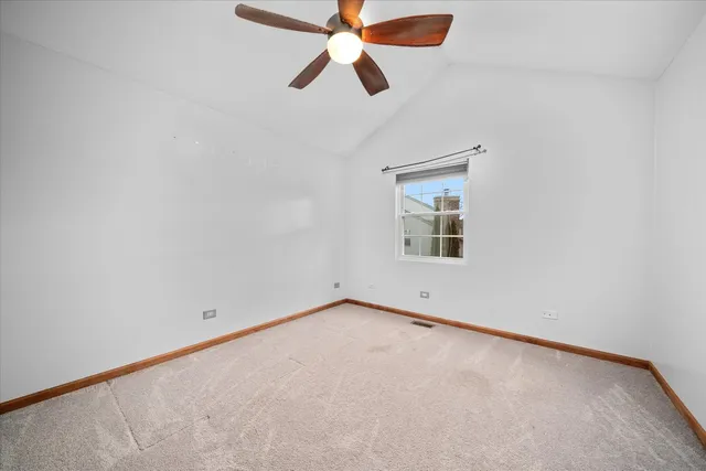 an empty room with chandelier fan