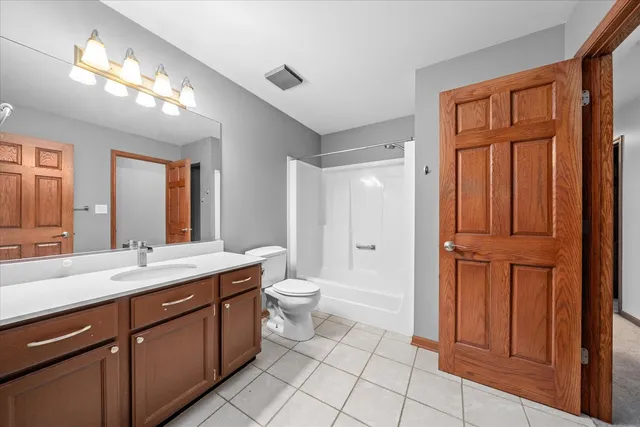 a bathroom with a double vanity sink a toilet and a mirror