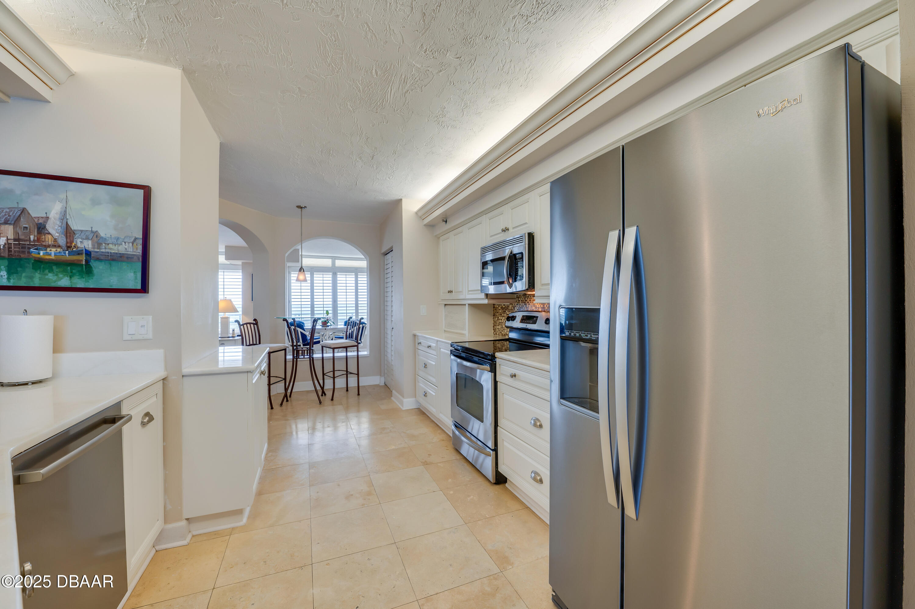 4525 South Atlantic Avenue, Unit 1704 Ponce Inlet, FL 32127 - Photo 13 of 45 a kitchen with stainless steel appliances a refrigerator a sink a stove top oven a dining table and chairs