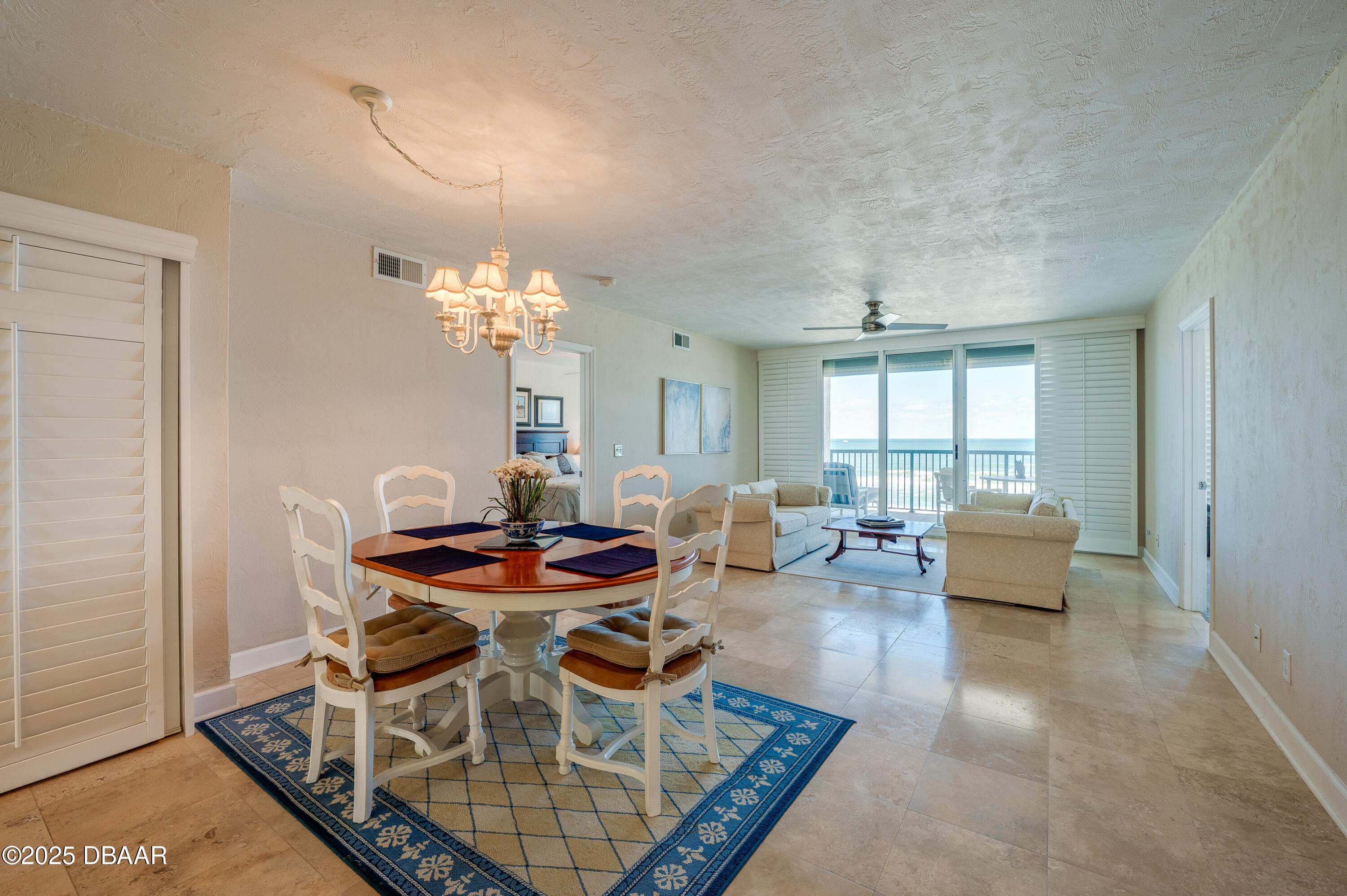 4525 South Atlantic Avenue, Unit 1704 Ponce Inlet, FL 32127 - Photo 16 of 45 a dining room with furniture a rug and a chandelier