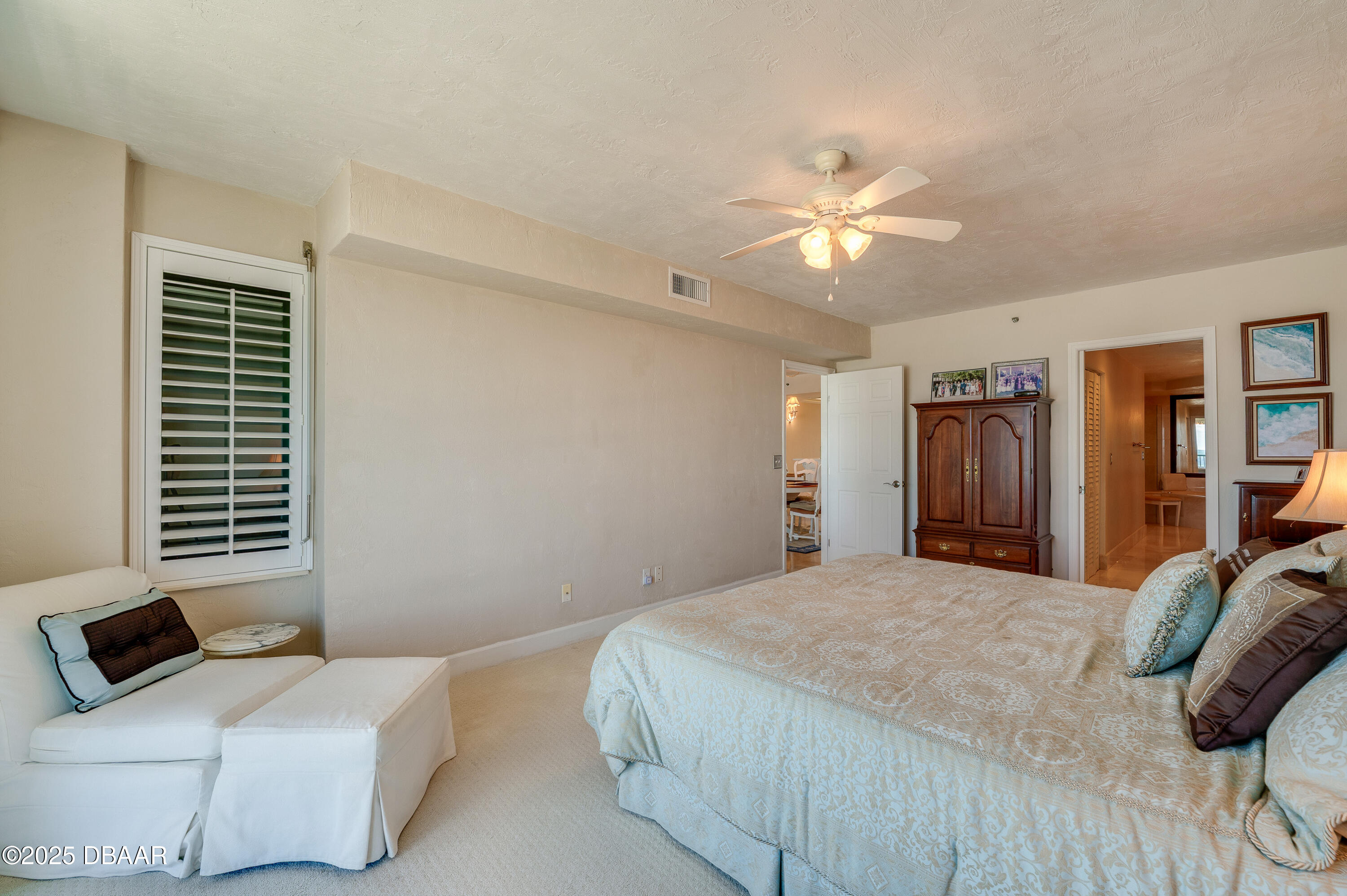 4525 South Atlantic Avenue, Unit 1704 Ponce Inlet, FL 32127 - Photo 21 of 45 a bedroom with a bed and a chandelier