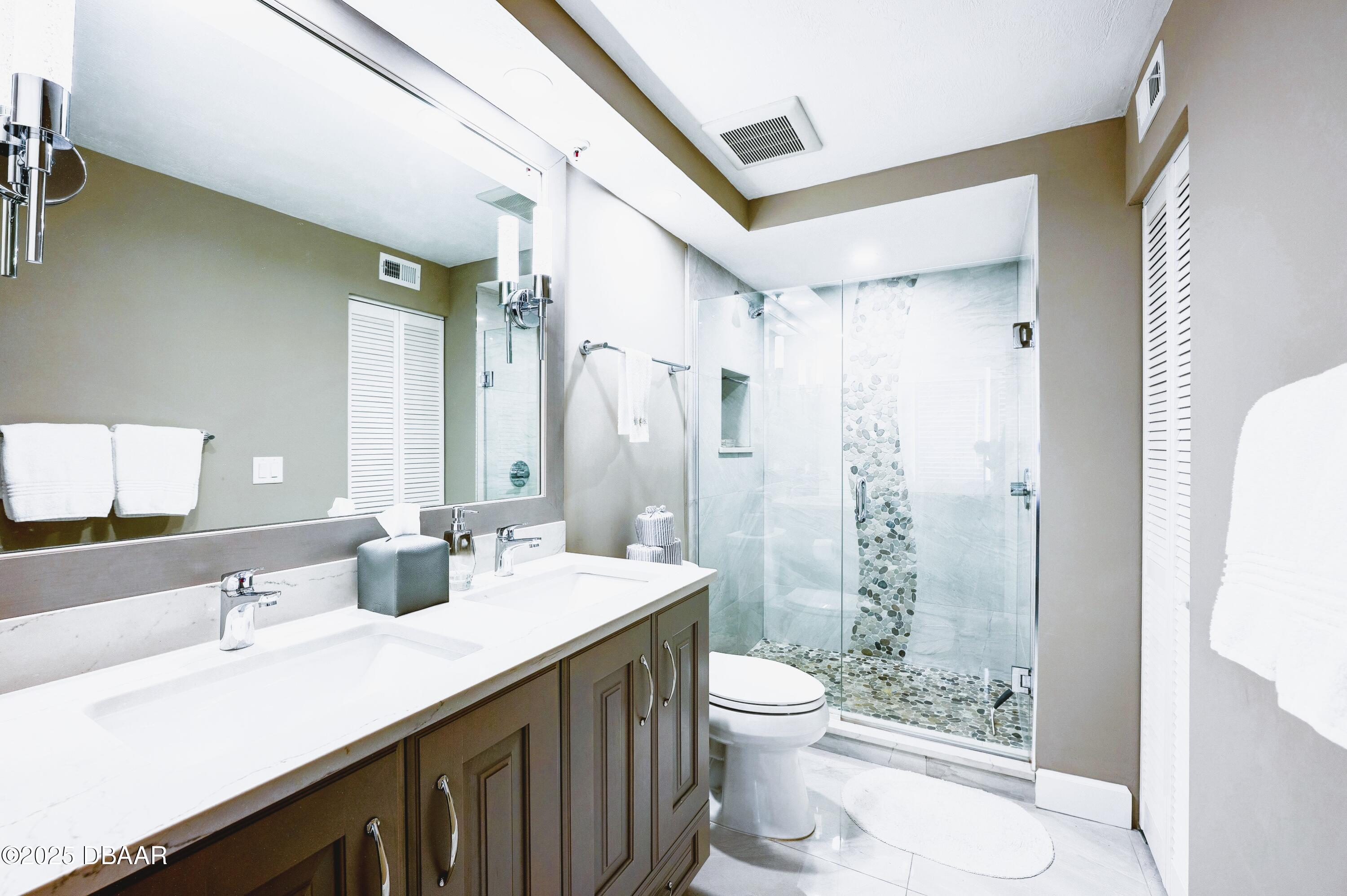 4525 South Atlantic Avenue, Unit 1704 Ponce Inlet, FL 32127 - Photo 28 of 45 a bathroom with a double vanity sink toilet and shower