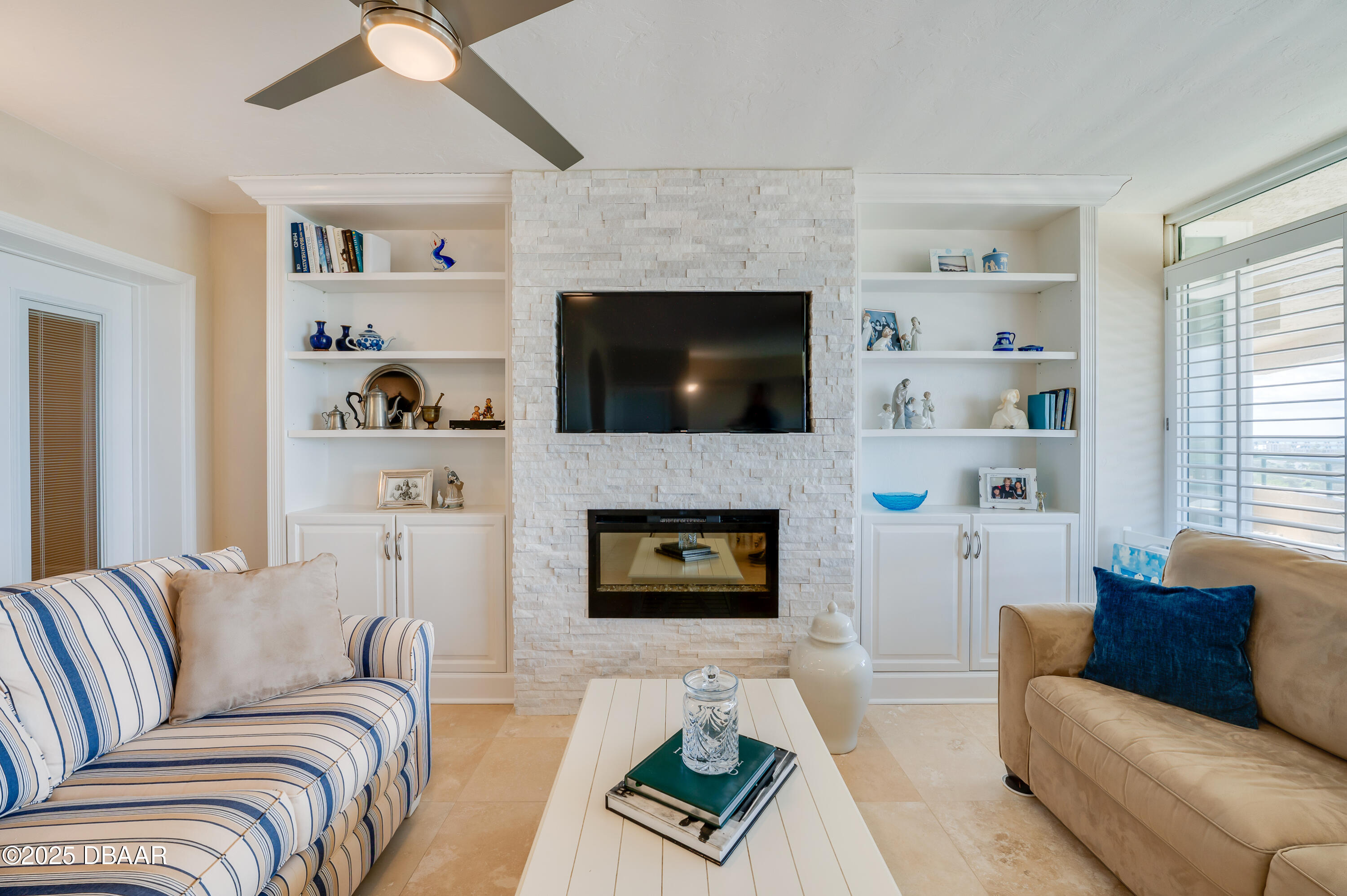 4525 South Atlantic Avenue, Unit 1704 Ponce Inlet, FL 32127 - Photo 9 of 45 a living room with furniture a flat screen tv and a fireplace