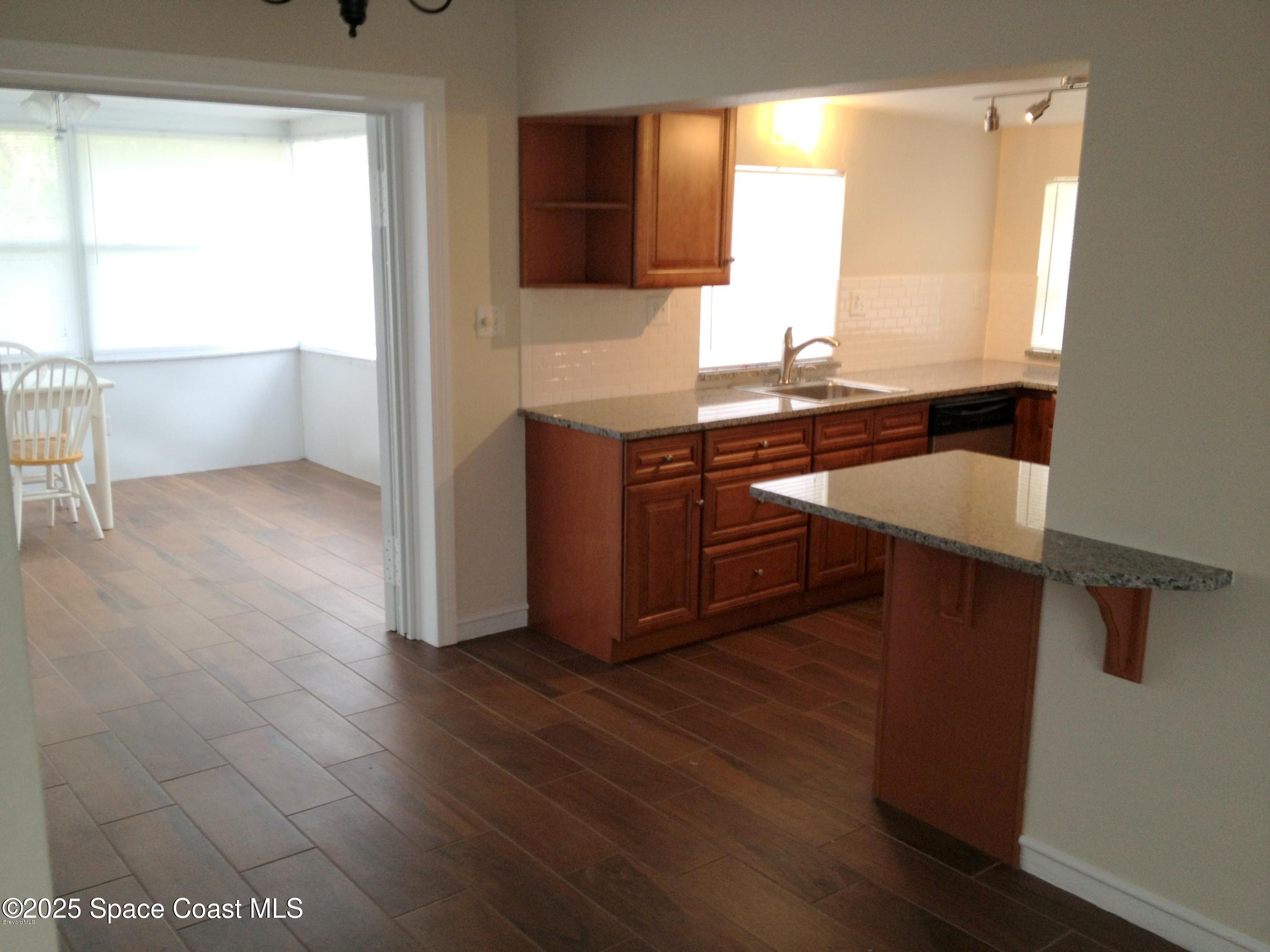 151 Delmar Street Indialantic, FL 32903 - Photo 3 of 6 a kitchen with a sink cabinets and wooden floor