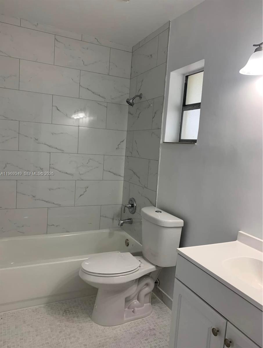 7505 Southwest 82nd Street, Unit 306 Miami, FL 33143 - Photo 5 of 9 a bathroom with a toilet a sink and shower