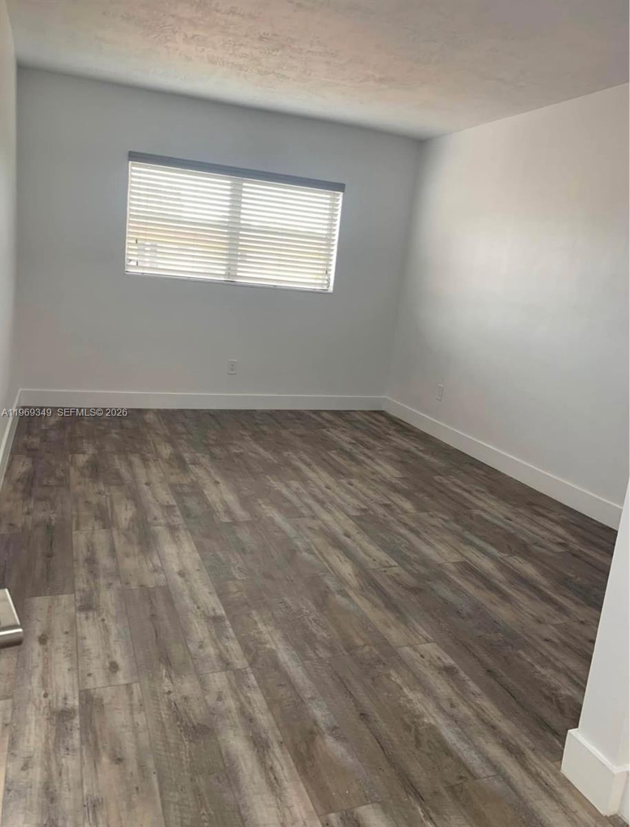 7505 Southwest 82nd Street, Unit 306 Miami, FL 33143 - Photo 6 of 9 an empty room with wooden floor and windows