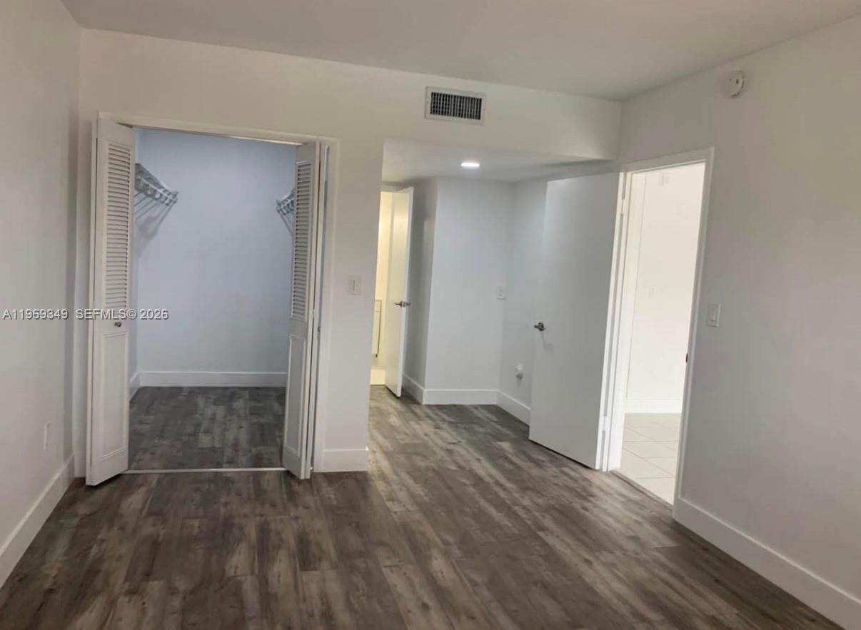 7505 Southwest 82nd Street, Unit 306 Miami, FL 33143 - Photo 7 of 9 wooden floor in an empty room with wooden door