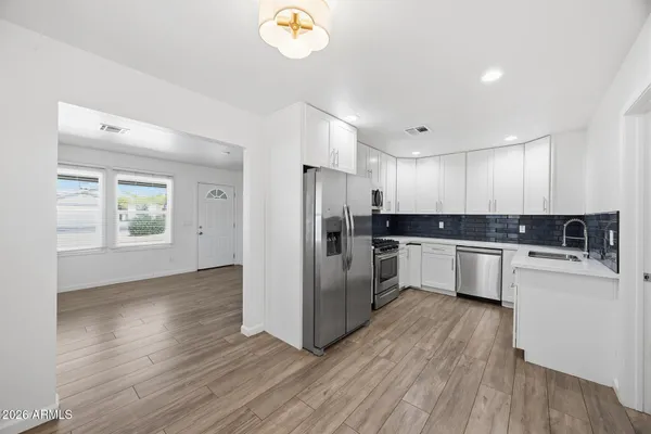 a kitchen with a refrigerator and a stove top oven