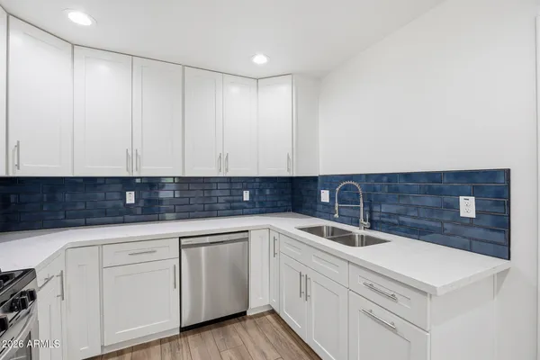 a kitchen with white cabinets sink and dishwasher