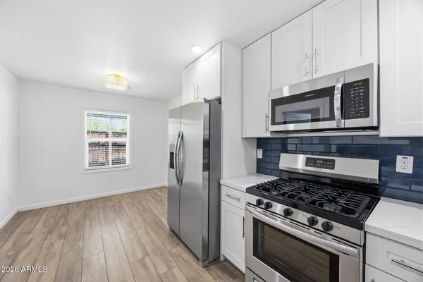 a kitchen with granite countertop wooden floors and stainless steel appliances