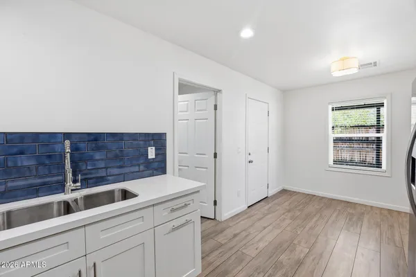 a view of a kitchen with a sink and wooden floor